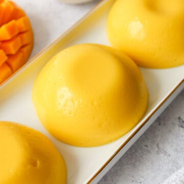 Chilled mango pudding fully set and ready to serve with evaporated milk.