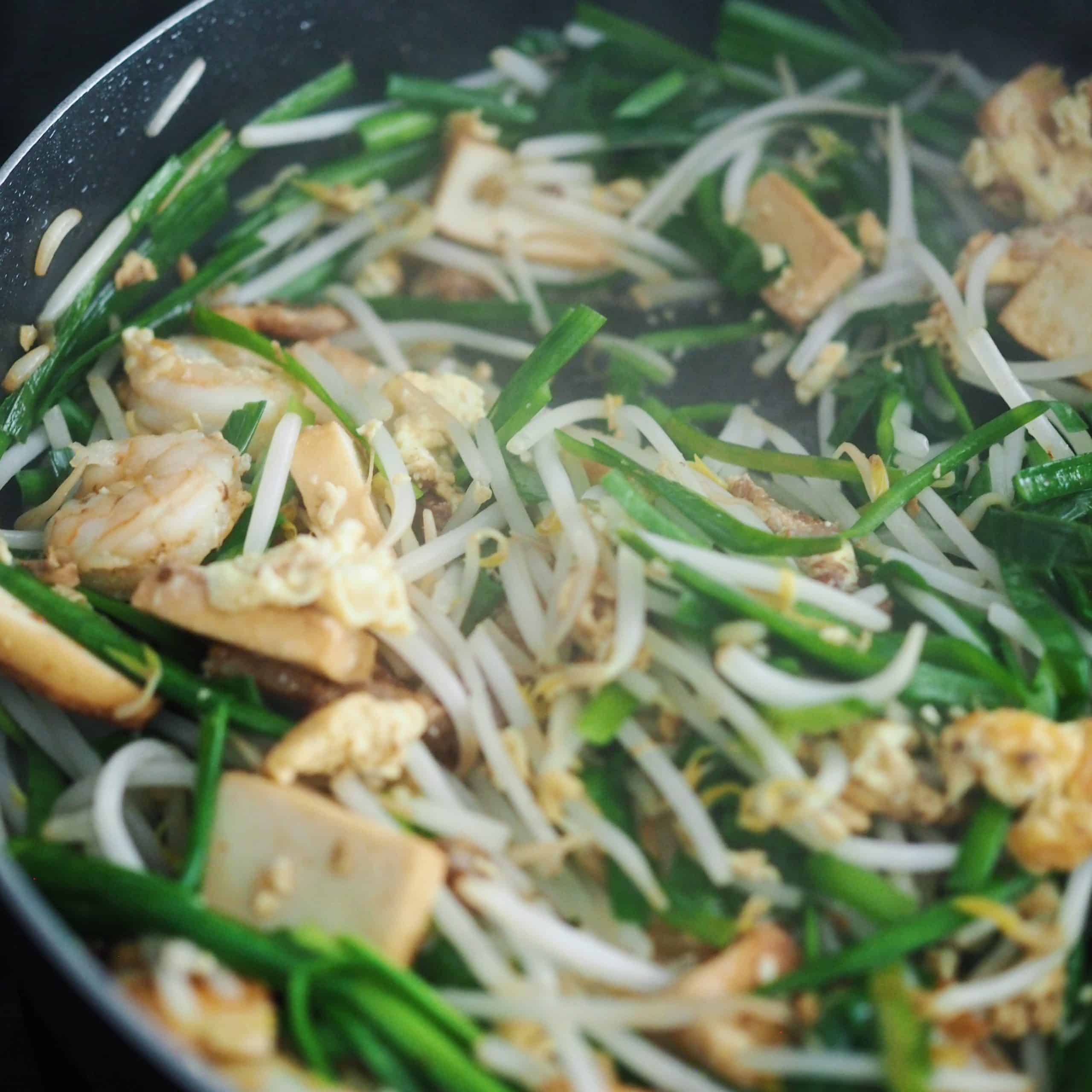 Throw in garlic chives and bean sprouts and cook until the veggies have wilted a bit.