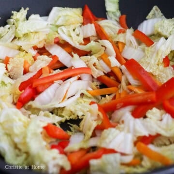 Add remaining oil into the pan. Sauté carrots, bell pepper, and cabbage for 60 seconds or until crisp and slightly tender.