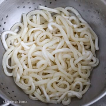 In a large bowl, soak your frozen udon noodles in hot boiling water just until loosened, about 30 seconds. Strain them and set aside.