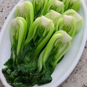 Blanched bok choy drained well and arranged on a serving plate.