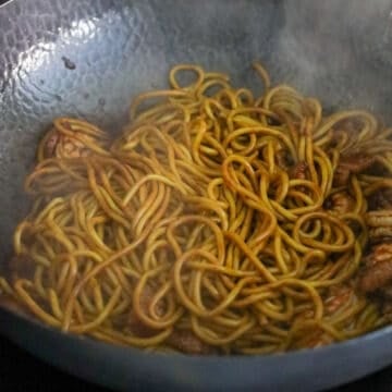 Thick yellow noodles tossing in a dark brown sauce with shrimp and pork.