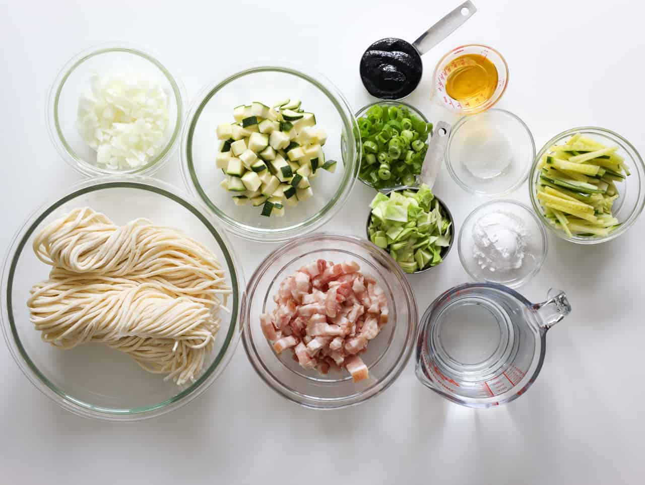 Fresh Korean wheat noodles, pork belly, chunjang, cabbage, zucchini, onion, green onion, cucumber, oyster sauce, vegetable oil, cornstarch, sugar, and water for jajangmyeon.