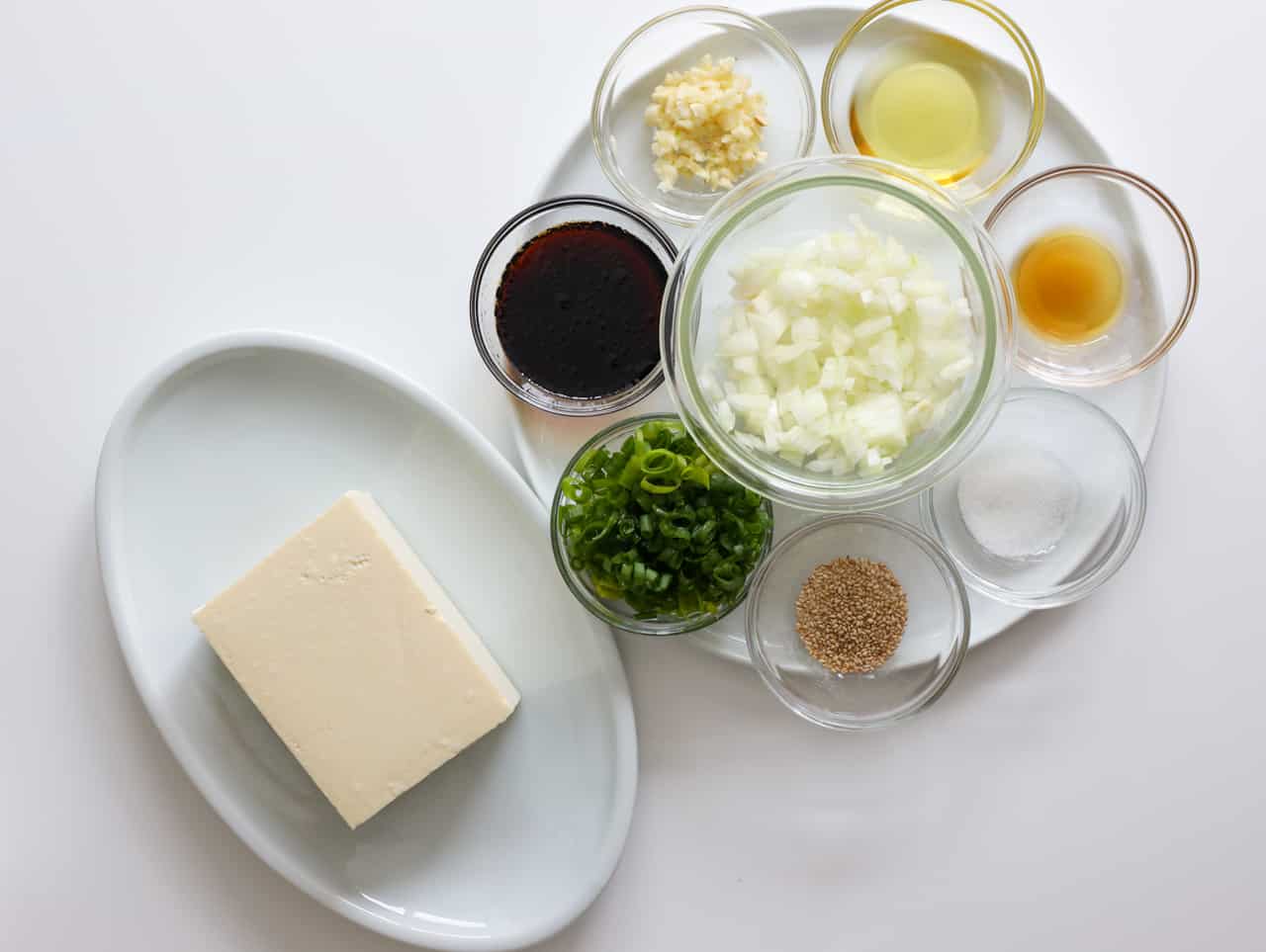Silken tofu, onion, green onion, garlic, soy sauce, sesame oil, sugar, sesame seeds, and vegetable oil to make Chinese silken tofu.