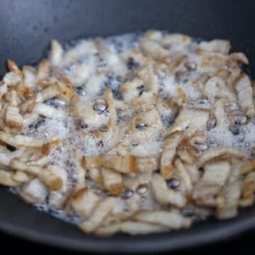 Pork belly cooking until browned with the fat rendered.
