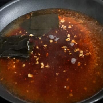 Sauce mixture stirred into a boiling pan.