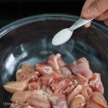 Diced raw chicken thighs cut into even one and a half inch cubes inside a large mixing bowl.