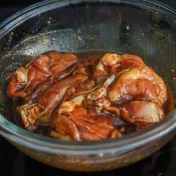Chicken thighs coated evenly in soy sauce marinade.