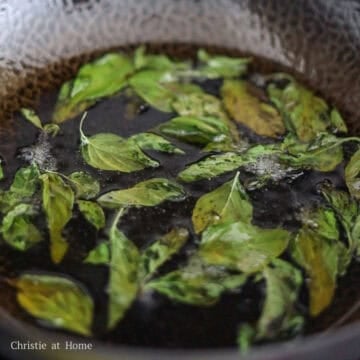 Thai basil leaves flash-frying in hot oil until crisp.