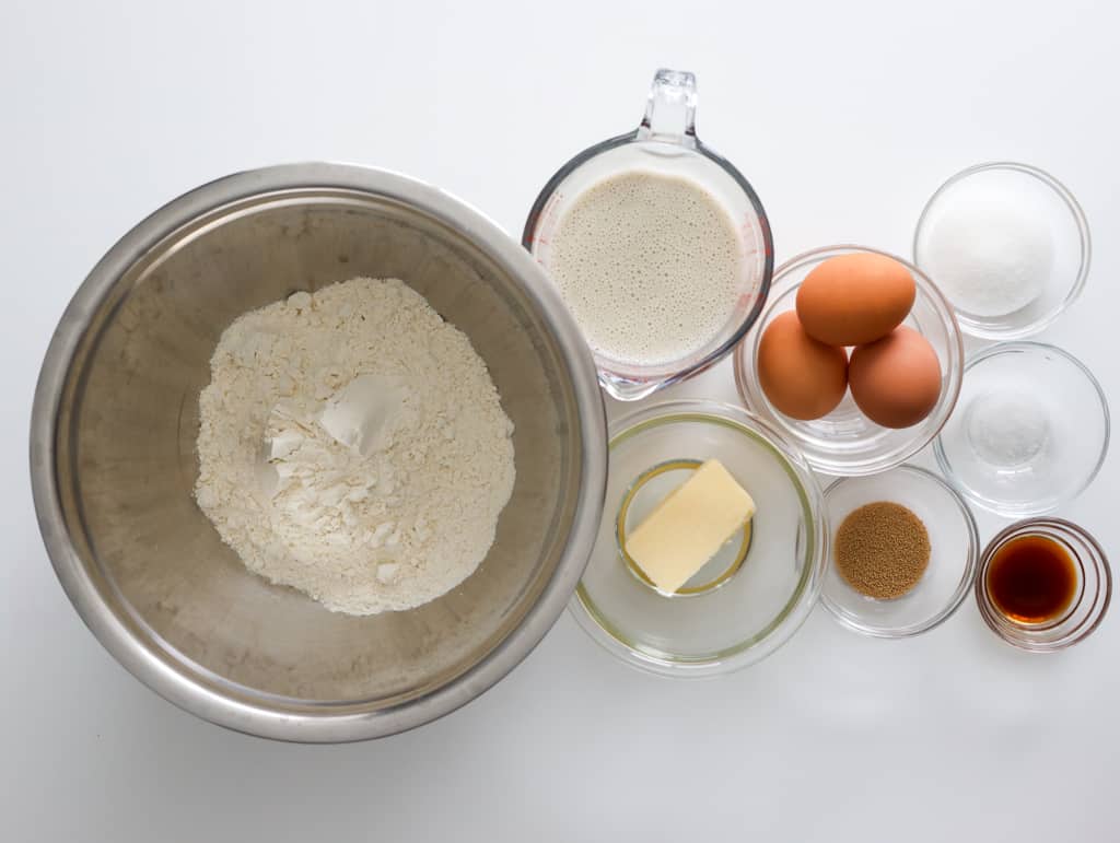 Ingredients for poffertjes including milk, eggs, vanilla extract, melted butter, flour, yeast, sugar, and salt.