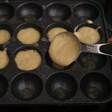 Poffertjes batter filling the greased wells halfway.