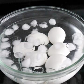 Boiled eggs cooling in an ice bath.