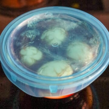 Peeled eggs submerged in soy marinade.