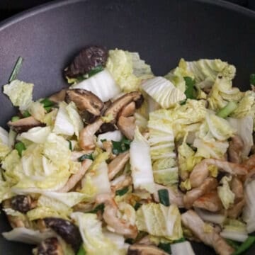 Next add napa cabbage, green onions and mushrooms. Stir-fry until wilted.