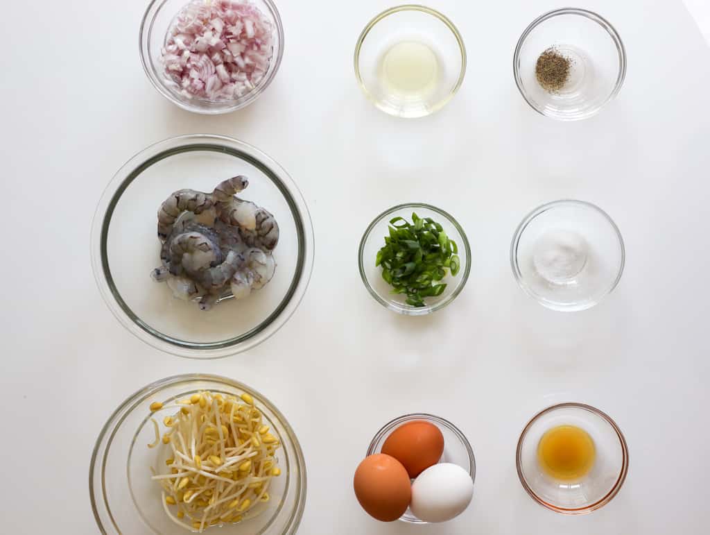 Main egg foo young ingredients including eggs, raw shrimp, soybean sprouts, shallots, green onions, sesame oil, salt, and black pepper.