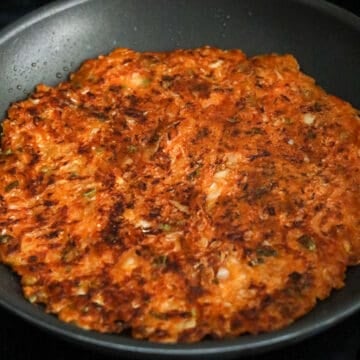Then loosen the sides with a spatula. When the pancake is ready to flip, you should be able to slide it around easily. Flip pancake over with the widest spatula you have or slide the pancake onto a plate and flip the pancake back into your pan. Pour remaining oil around the edges and fry on the other side until golden and crispy, another 3-4 minutes.