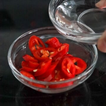 In a small bowl, combine red chili and white vinegar. Set aside.