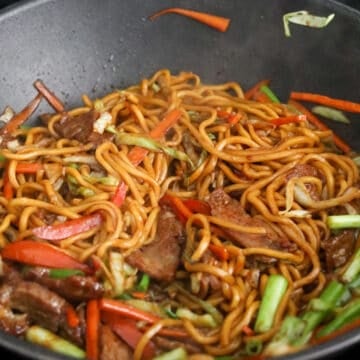 Glossy lo mein noodles tossed with sliced beef, carrots, cabbage, and green onions.