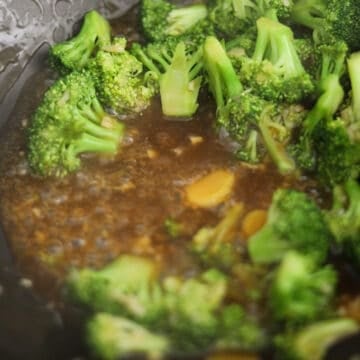 Broccoli beside glossy, thickened stir-fry sauce.