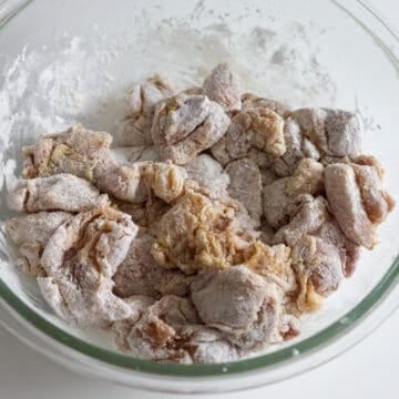Evenly coated raw chicken pieces covered in a dry layer of cornstarch.