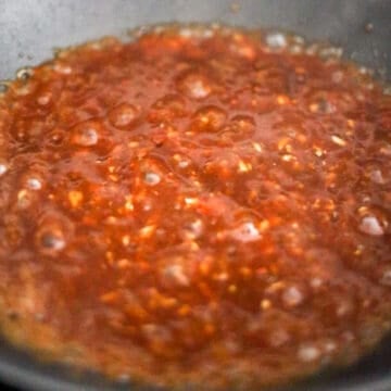 Thick brown stir-fry glaze bubbling as it reduces into a glossy sweet and savory sauce.