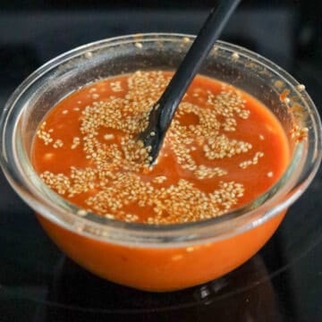 A small bowl filled with mixed gochujang sauce ingredients, whisked together until smooth and combined.
