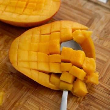 Fresh mango flesh scored into cubes and scooped from the skin.