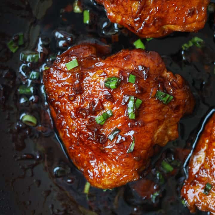 Basted soy sauce chicken thighs topped with chopped green onions.