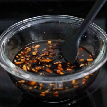 Dark brown soy sauce marinade being mixed in a bowl.