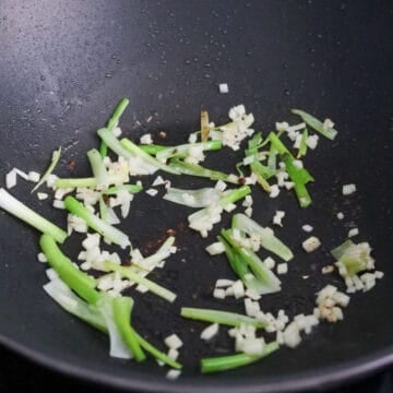 With the residual oil in the pan, fry scallion whites only and garlic for 10 seconds.