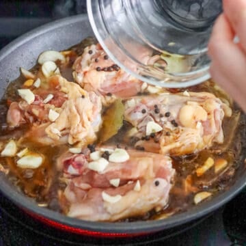 Chicken thighs with soy sauce, vinegar, garlic, peppercorns, and bay leaves.