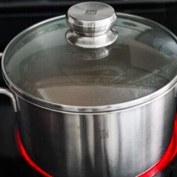 In a pot combine chicken broth, soy sauces, sesame oil, chicken bouillon, and sugar and bring to a boil.