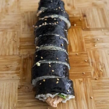 Spicy tuna kimbap sliced into 1-inch pieces and garnished with sesame seeds.