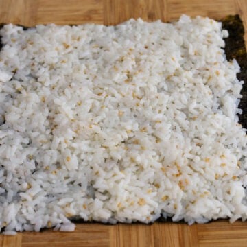 Seasoned rice spread evenly over a sheet of gim with a 1-inch border.