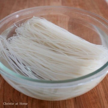 Dried rice vermicelli soaking until limp and pliable.
