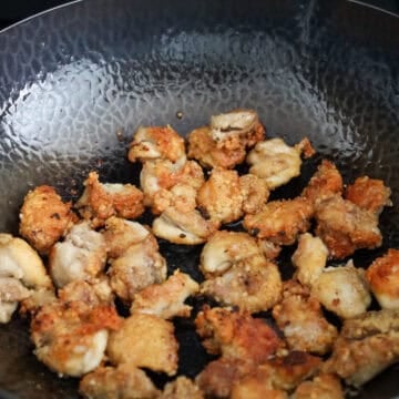 Chicken frying in hot oil until golden and crispy.