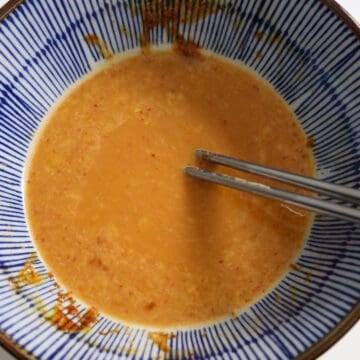 Very slowly pour half of the piping hot ramen water into the serving bowl with the mayo egg mixture while mixing. Do not just pour all the noodle water into the bowl or it will fully cook the eggs.