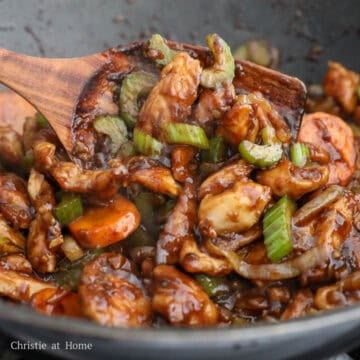 Cooked chicken returned to the pan, tossed in sauce, and plated for serving.