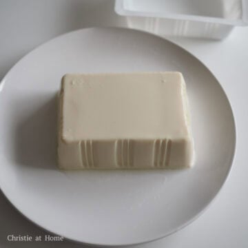 Smooth block of chilled silken tofu resting on a serving plate.