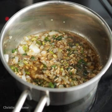 Savory soy sauce simmering with softened onions, green onions, and garlic.