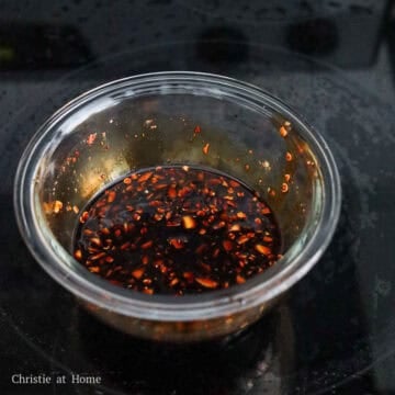 Dark brown savory sauce blend sitting undisturbed in a small container.
\