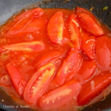 Softened tomatoes simmering in a thick, glossy sweet and tangy sauce.
