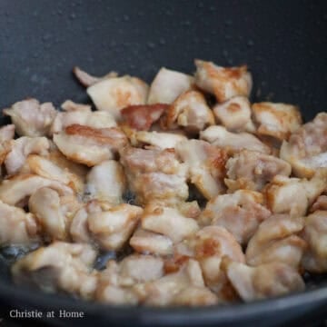 Golden-brown seared chicken pieces glistening with oil.