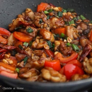 Seared chicken, peanuts, and crisp vegetables fully coated in a thick, glossy mahogany glaze.