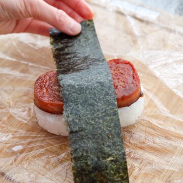 Spam musubi with glazed spam, sticky rice, and nori wrapped around the middle.