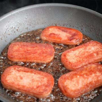 Golden pan-fried spam coated in a thick, glossy soy glaze.