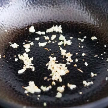 Finely minced garlic sizzling in hot oil until fragrant.