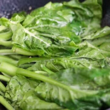 Chinese broccoli stir-frying with water and minced garlic.