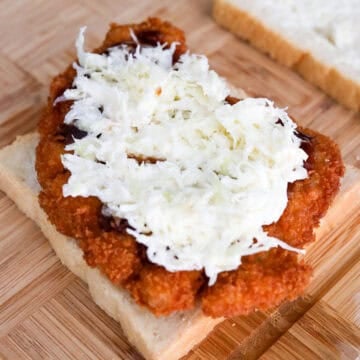 Butter both slices of bread. Layer a piece of pork katsu on top, drizzle Tonkatsu sauce over top, followed by equal portion of cabbage slaw and close off with slice of bread.