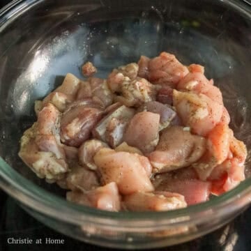Diced raw chicken thighs mixed with wine, salt, and pepper.